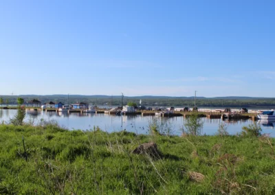 view of marina from a distance showing boats and the forest landscape behind - Marina on Lake Superior
